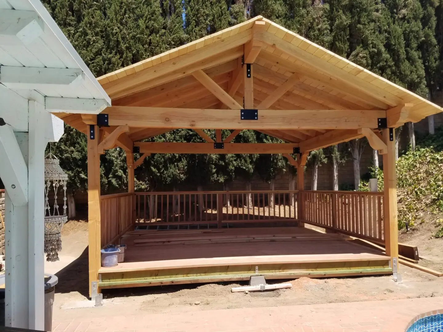 A wooden structure with a roof and a deck.