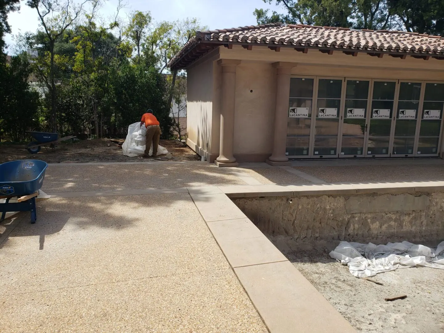 A man in an orange shirt is working on the pool.