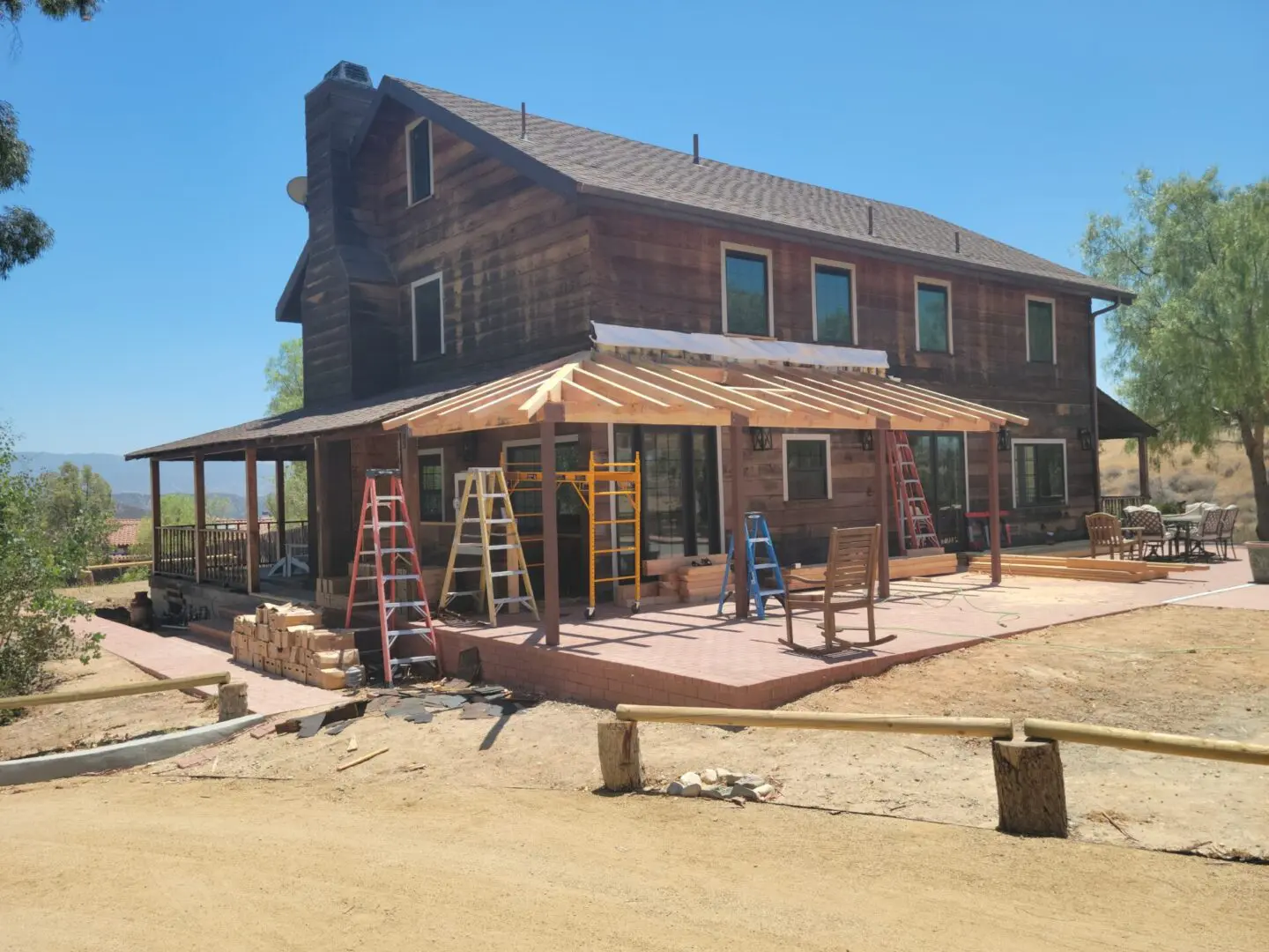 A house being built with a ladder and some chairs