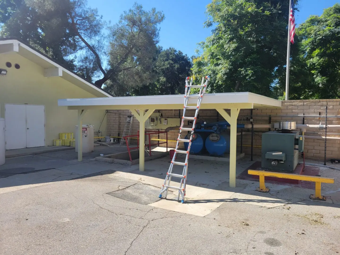 A ladder is in front of a carport.