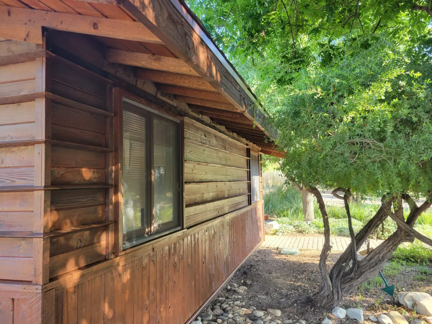 A wooden cabin with trees in the background.