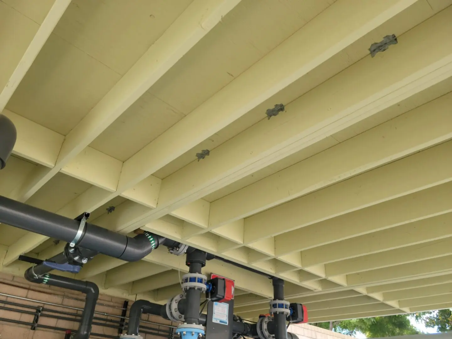 A close up of pipes under a wooden structure