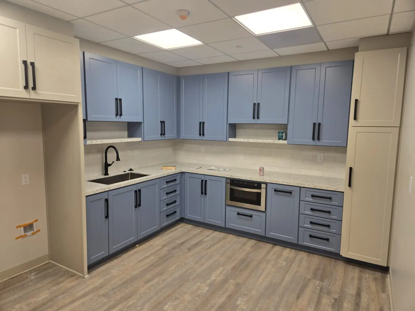 A kitchen with blue cabinets and white counters.