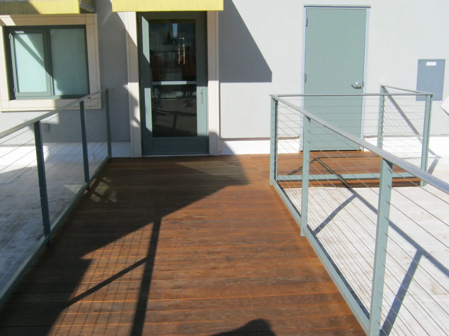 A building with a wooden deck and metal railing.