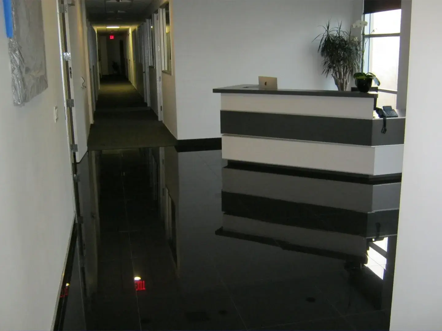 A hallway with black water on the floor.